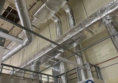 Insulated ductwork in an industrial or commercial building's ceiling area.