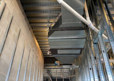 Interior construction zone with exposed metal studs and ductwork.