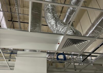 Interior view showing exposed ductwork and insulation above a drop ceiling.